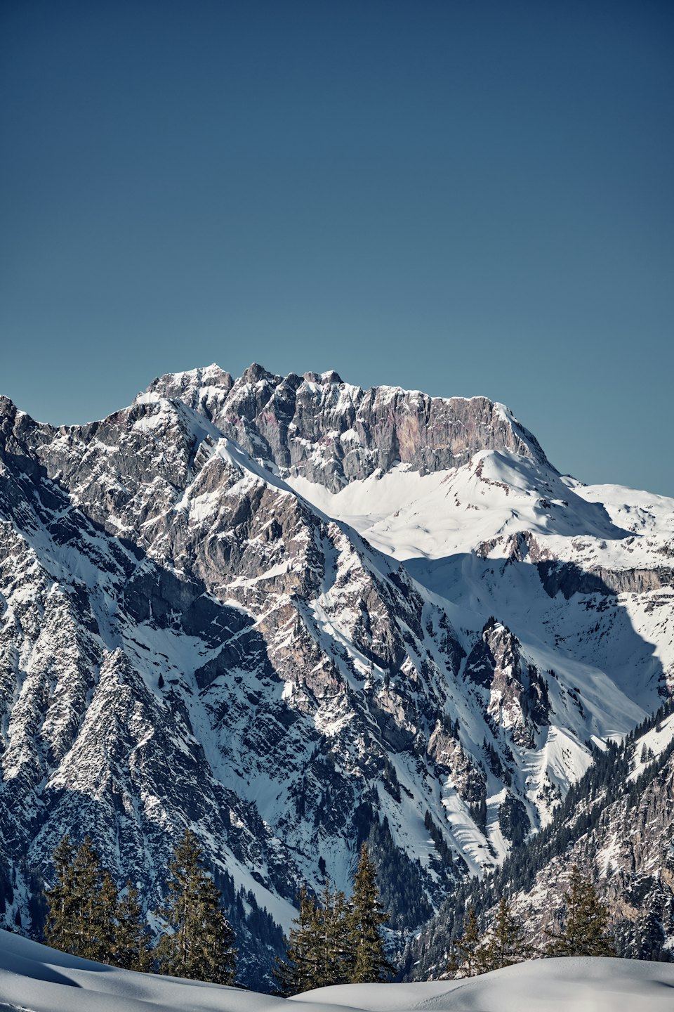 Montagne innevate sotto un cielo azzurro limpido.